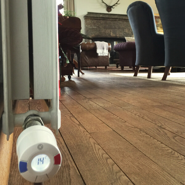 A photo of a lounge at the Bossington Hall Hotel, with a radiator on the left of the photo. There is a Wireless Radiator Valve mounted horizontally with the set temperature displayed.