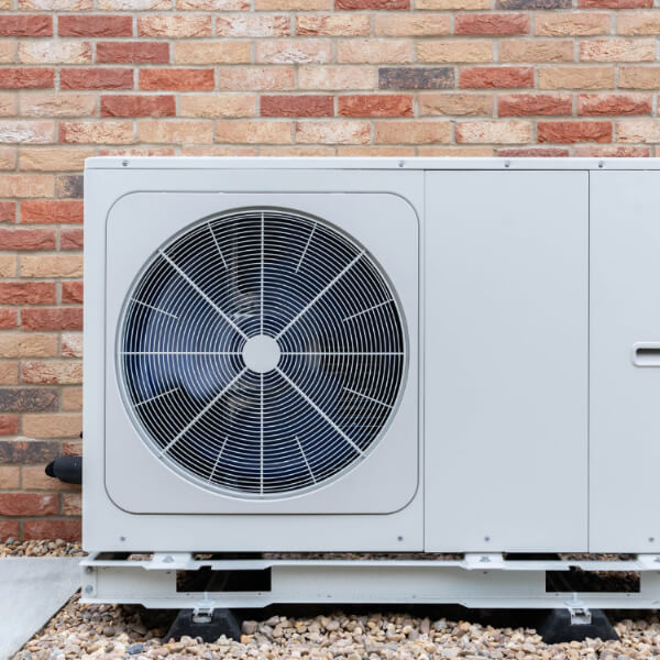 Image of a ventilation unit on a stone floor, with a brick wall behind it.